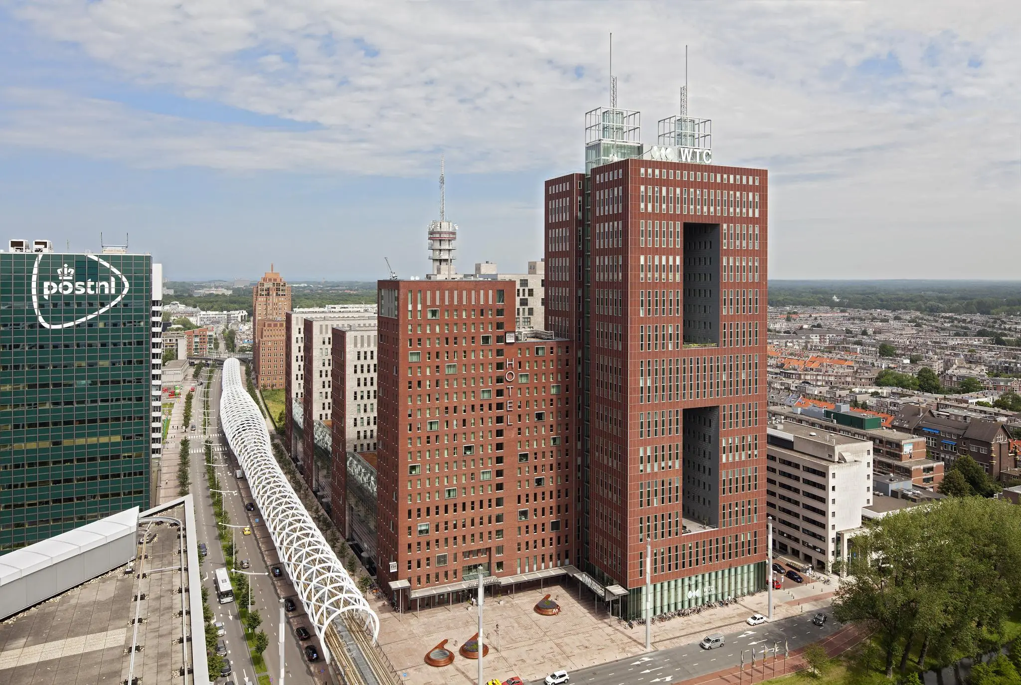 Hoogbouw aan de Prinses Beatrixlaan in Den Haag met opvallende rode WTC-toren en overdekte tramlijn.